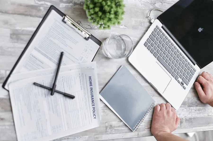 Reviewing a home insurance policy and renewal paperwork at a desk