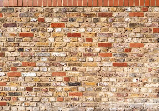 Weathered yellow London stock brick with red brick patches, the type used for chimney stacks on older Croydon terraces