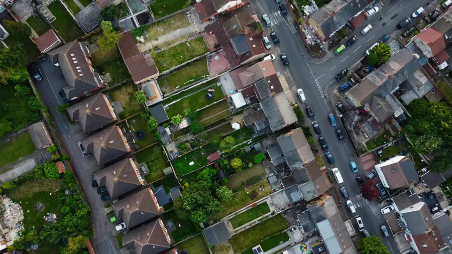 Top-down view of a row of terraced houses showing the lower rear addition roofs projecting into the back gardens