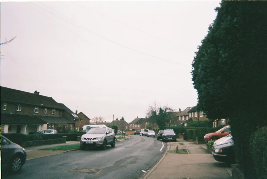 A street of 1930s houses under a grey sky, built before roofing felt was standard