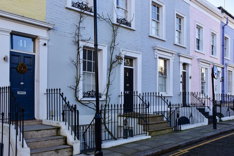 Painted Victorian terraced houses on a London street with slate roofs above the front elevations