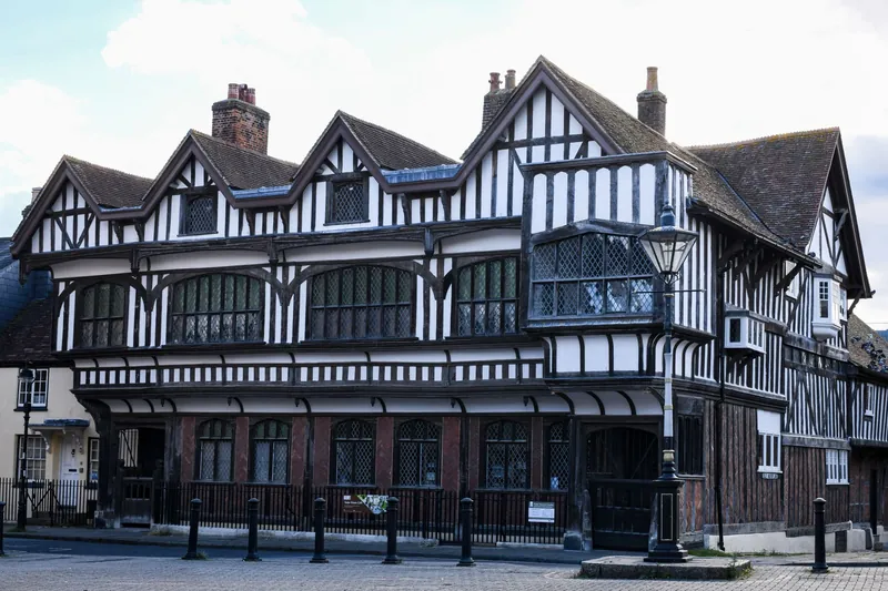 Tudor style building with black and white timbered gables and clay tile roofs