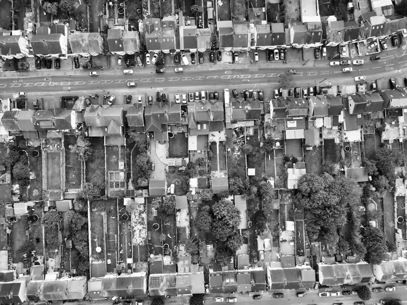 Black and white aerial view of houses with rear extensions and long back gardens