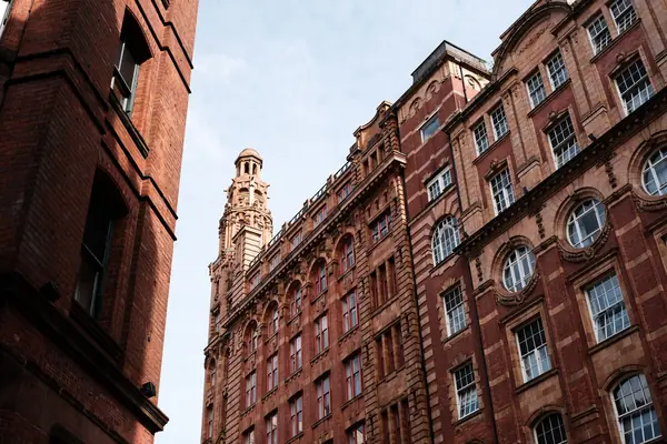 Edwardian red brick building with tall windows and a corner tower