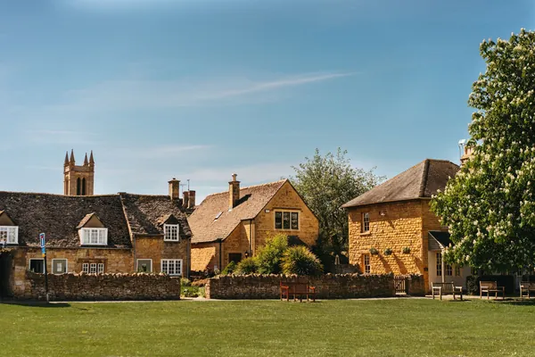 Village green with old houses and a church tower beyond